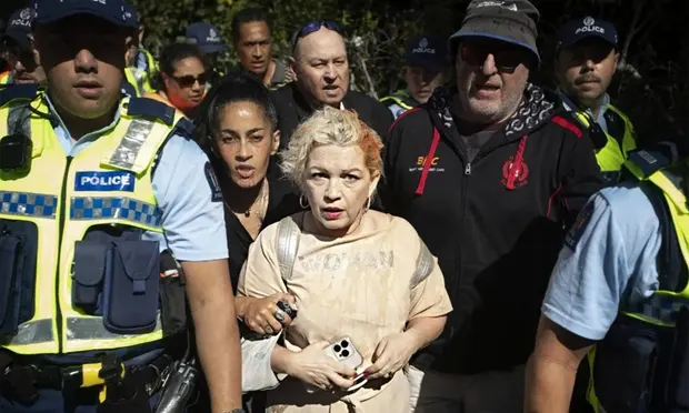Anti-trans activist Posie Parker is escorted from her Auckland speaking event by police after being met by thousands of pro-trans rights counter-protesters. Photograph: Stuff/Chris McKeen