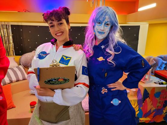 María Arranz viene ataviada de cocinera espacial con su mono blanco de la NASA y su delantal. A su lado 99, una inteligencia artificial en prácticas, con su mono azul y su rostro plateado.