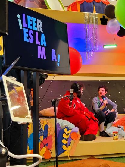 Sonia Fernández Pan sentada con 0, un simio astronauta vestido con su mono rojo. En la pantalla se ven unas letras que hay que ir completando: es la clave que permitirá arrancar la nave...

¡LEER ES LA  _ _ M _ A!