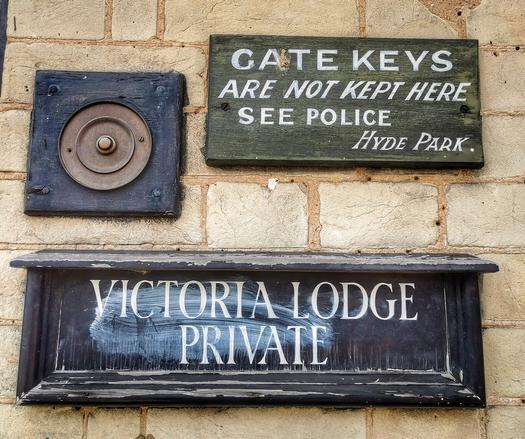 Two signs on Victoria Lodge in Hyde Park, London. The less interesting one says, 'Victoria Lodge, Private', the more interesting one says, 'Gate Keys Are Not Kept Here, See Police Hyde Park' in an  old-fashioned type script.