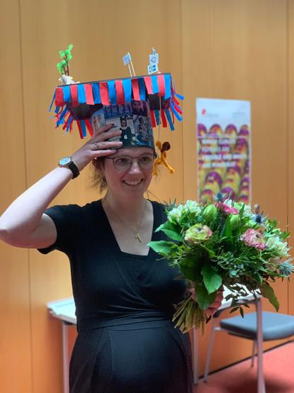 Photo of Mia Sophie Specht with her PhD hat holding flowers.