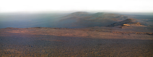 This is a color mosaic made from raw images acquired on March 10, 2017 from NASA's Opportunity rover, now in its 14th year of operation on Mars.

It shows a view from the rim of Endeavour Crater in Meridiani Planum. 

The image was made by creating three color images from raw data acquired in near-infrared, green, and blue color channels and then sticking the resulting color images together to create a wide angle panorama. Some blurring along the seams is evident, as well as some slight tonal variations where vignetting was reduced. Also the sky has been expanded past the original range of the images. Color is not calibrated.

The haze is due to fine dust in the air, which can also scatter and absorb light to create blue colorations.

Credit: NASA/JPL-Caltech/Jason Major
twitter.com/JPMajor
