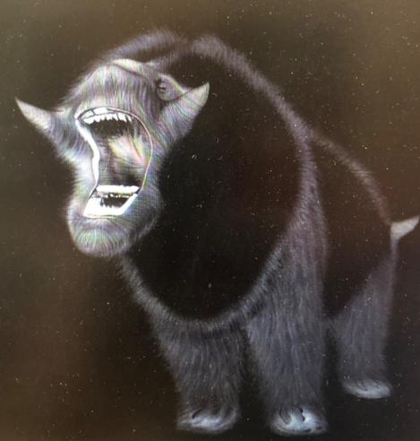 Black and white image of an imagined creature, fury with open mouth and little horns.