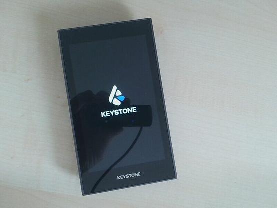 Keystone Hardware Wallet with display showing the Keystone logo.