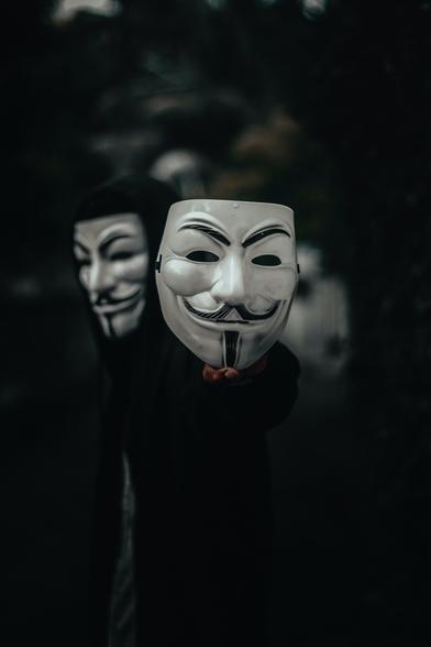 A stock photo by Ahmed Zayan, via Unsplash.com, of three Guy Fawkes masks with one facing forward in the foreground and two facing outward in the background.