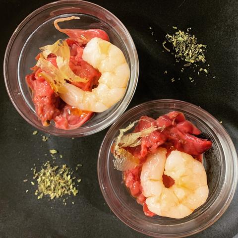 Special birthday supper for Space Cats: 

chicken liver, king prawn, salmon oil drizzle, garnish of bonito, and catnip on the side.

Two glass bowls on a black plate.