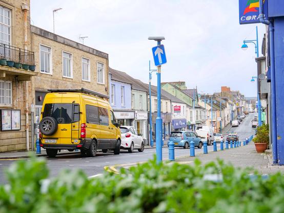 Steffi's und Lui's gelber Camper Maja parkt in Pembroke Dock vor dem Gemeindezentrum Pater Hall.