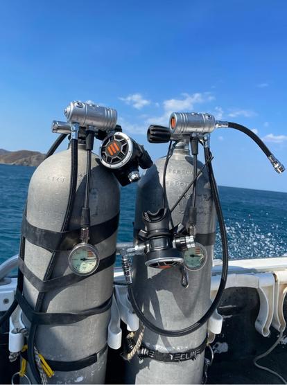 A sidemount scuba diving configuration is mounted on two independent scuba cylinders. on the back, there's a visible mount where the sea lin