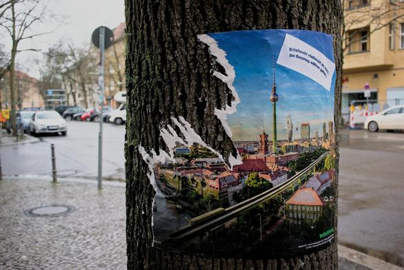 ripped poster attached to a tree. The poster is part of the Berlin 2030 climate referendum that failed. The poster shows a green Berlin.