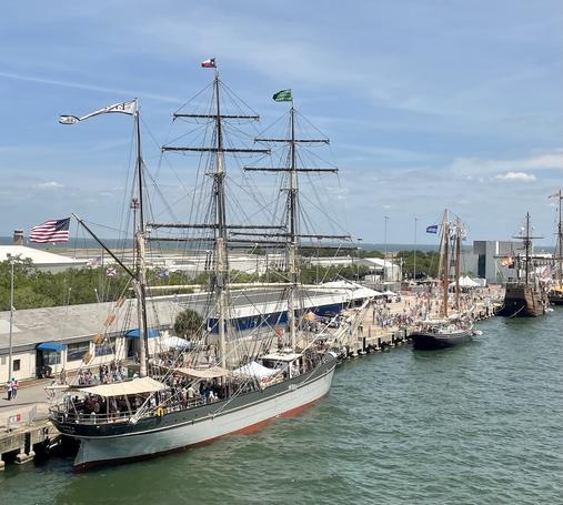 Several tall ships (with sails down unfortunately) tied up along the seawall