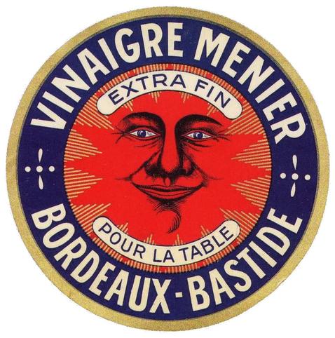 Étiquette ronde Vinaigre Menier Bordeaux-Bastide. Texte blanc sur fond marine. Mentions en cartouche : Extra fin et Pour la table. Illustré d’un visage masculin jovial (qui évoque le soleil) se fondant dans un fond rouge.