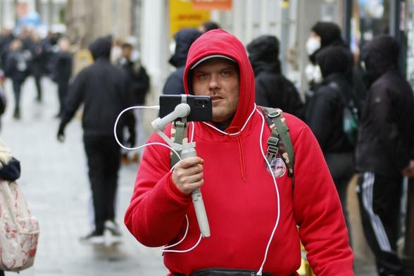 Kevin Gabbe streamt in einem roten Pullover