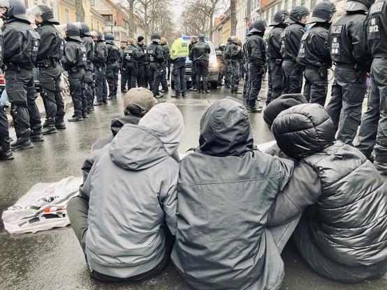 Sechs Personen sitzen auf der Straße