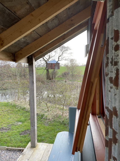 View from the bothy, pond in foreground with tree house in the background
