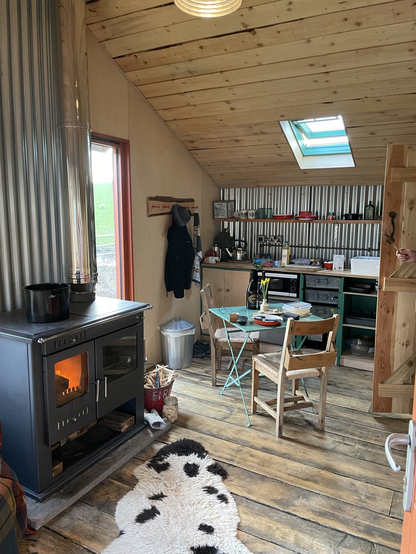 Bothy interior with wood burning range, kitchen table and bothy kitchen