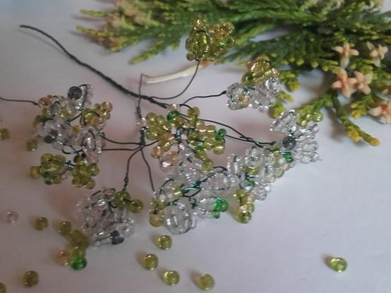 White greenish flower umbels of Queen Anne's lace made from tiny glass rocailles in French beading / perlage technic.
