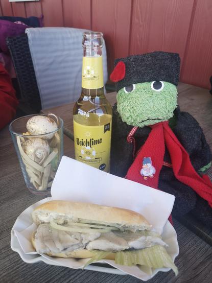 Joschka serviert ein Fischbrötchen und Holunderlimo