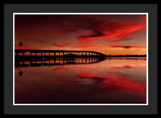 Ormond Beach, Florida bridge sunset, with mirrored reflections on the Halifax River at sunset. Gorgeous sunset with lots of orange and red here.