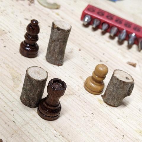 three chess pieces, a rook, a bishop, and a pawn, each next to a stick cut to equal size
