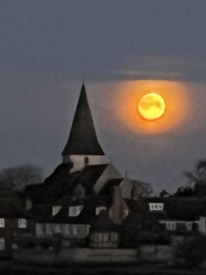 moon set over an old church in an English village