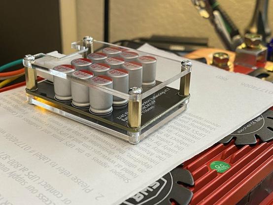 A photo of a 5 amp 4S LiFePO4 active balancer with its yellow "run" light on, indicating active balancing between parallel cell groups.