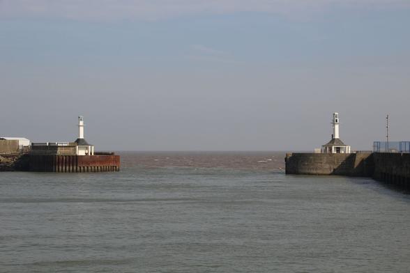 A harbour entrance marked by two small light towers.