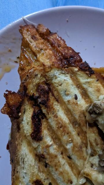 Toasted sandwich, in the corner the leaked melted cheese