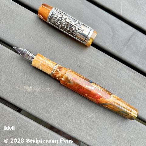 Idyll pen, uncapped, on picnic table. Features custom Silver Panel Rollstop engraved with the image of a maple tree.