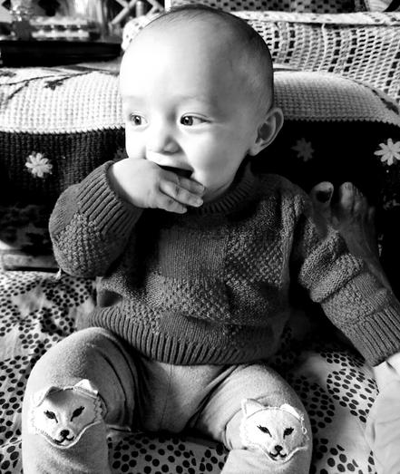 Baby nephew eating his hand. Monochrome photo.