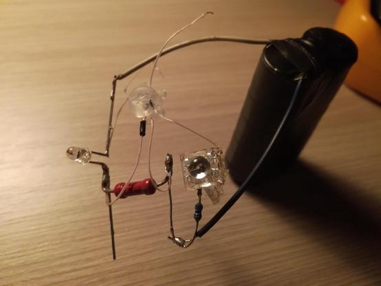 poit-to-point soldered ATTiny10, phototransistor, LED “Piranha” and two resistors. wires from the battery pack are soldered to the circuit too.