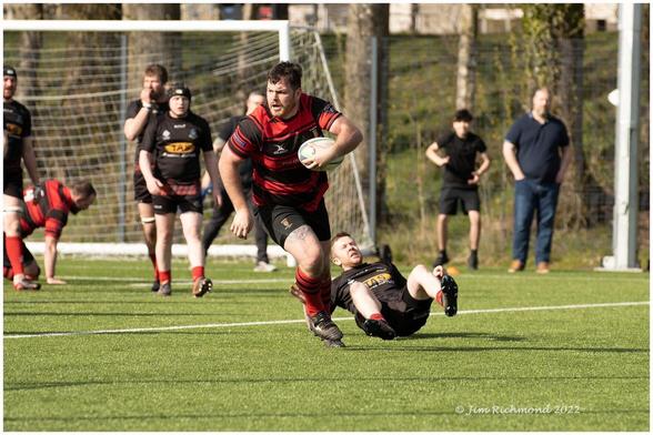 Rugby player  runs into goal area having knocked an opposition player onto his backside