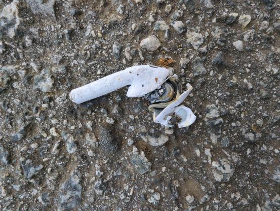 A smashed AirPod on the road