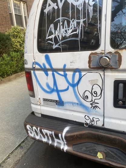 tags on the back of a white van including SOUTH and UFO907