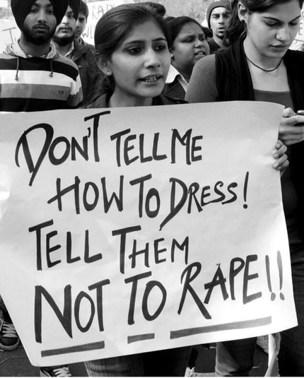 Women holding up a sign, Don't tell me how to dress. Tell them not to rape