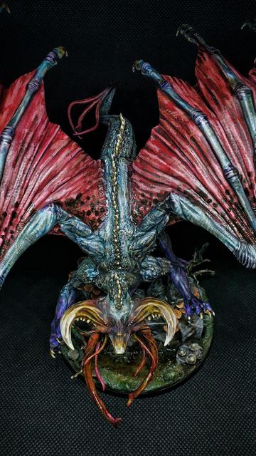 The same mini from above, showcasing the brown speckling on the red wings, as well as the dragon's massive horns.
