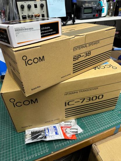 An expensive pile of cardboard boxes containing an Icom IC-7300 transceiver and matching SP-38 external speaker

also an SWR/power meter, dummy load and some PL259 plugs for another project
