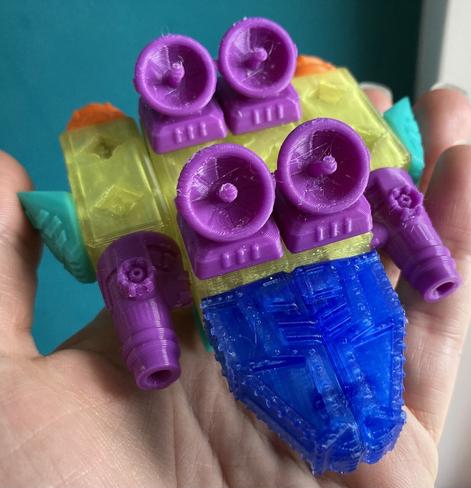A multicoloured assembled 3d print of something my kid considers a space ship with weapons (those are antennas but I'm not arguing).