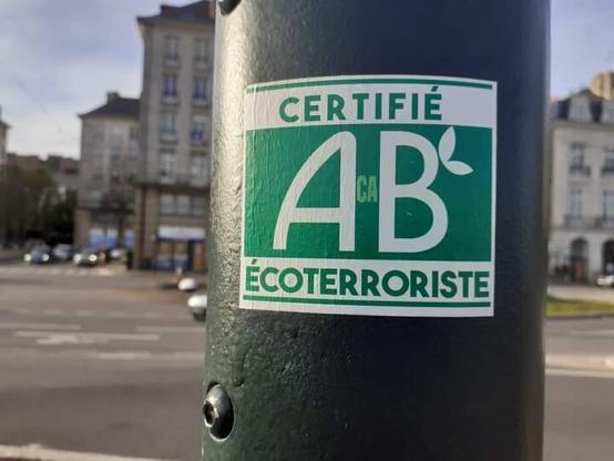 Sticker colle sur un poteau détournement du label AB renommé AcaB Certifié Ecoterroriste