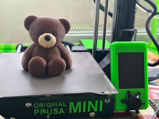 Barry the bear 3D print sitting on the Prusa Mini build plate, with a brown textured body, black eyes, black nose and cream snout