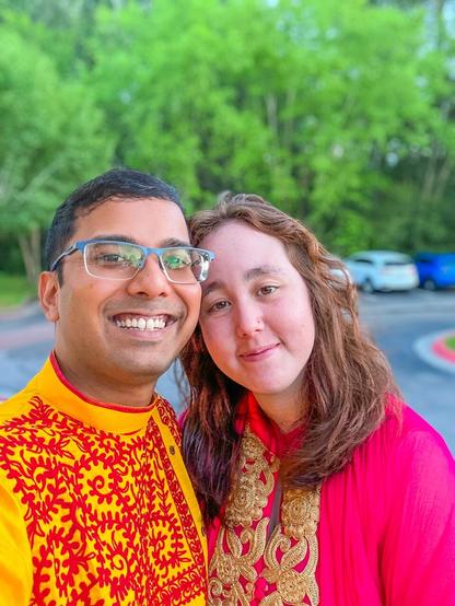 A man and a woman wearing traditional Indian clothes (Kurta, and Salwar) smiling at the camera
