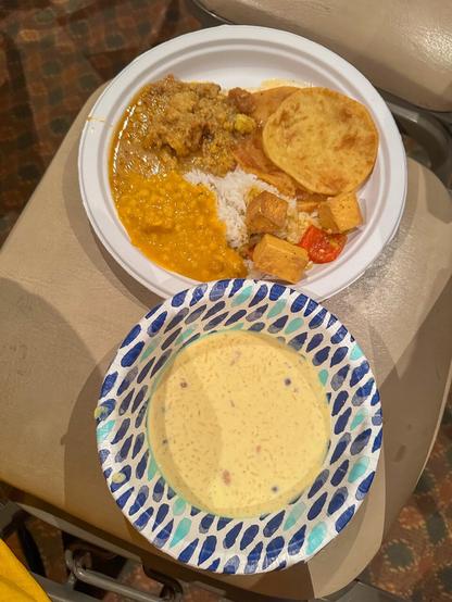 An assortment of Bengali food on plate (rice, paneer, chickpea curry, lentil cake curry [Dhokar Dalna], Payesh)