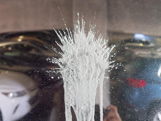 A white splash on a mirror in a parking garage.