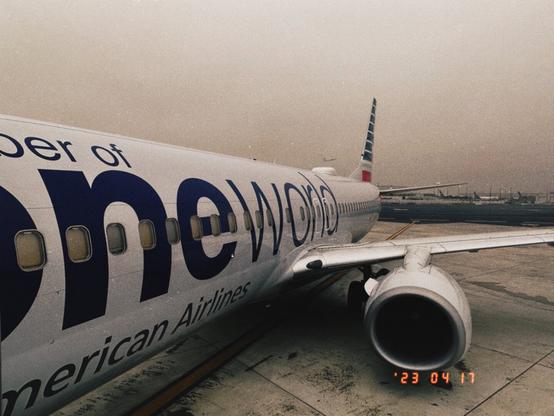 View of aircraft fuselage, engine and wing parked at gate.