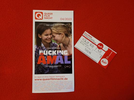 Das Photo zeigt mein Ticket für die Kinovorstellung des Films "F*cking Åmål" neben einem Flyer mit näheren Angaben zu dem Film.