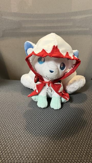 An Alolan Vulpix plushie, wearing a hand-crafted White Mage cloak. Front view.