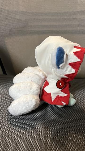An Alolan Vulpix plushie, wearing a hand-crafted White Mage cloak. Side view.