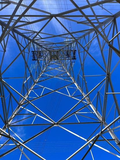 Looking up the middle of a transmission tower from underneath