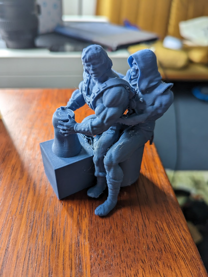 A 3D printed model of He-Man and Skeletor posed in front of a pottery wheel like the famous scene from the movie "Ghost"