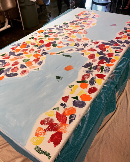 Mural of a tree stamped with color by first and second graders
