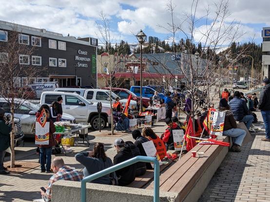 PSAC members striking in front of the Elijah Smith building in Whitehorse, Yukon, with flags and picket signs visible, and Coast Mountain Sports across the street in the background.